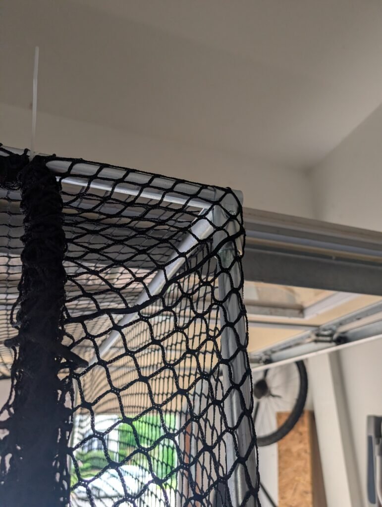 DIY golf simulator enclosure frame built from EMT conduit and corner connectors